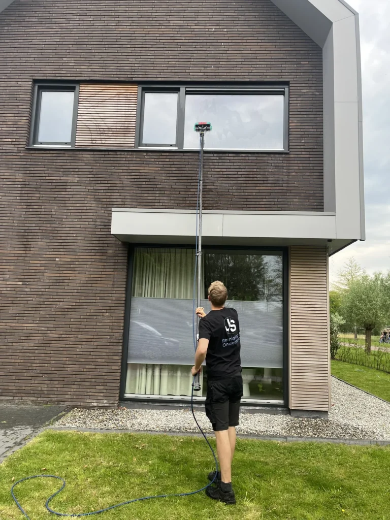 JS Reiniging wast hoge ramen met een telescoopsteel